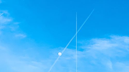 Low angle view of vapor trail against blue sky