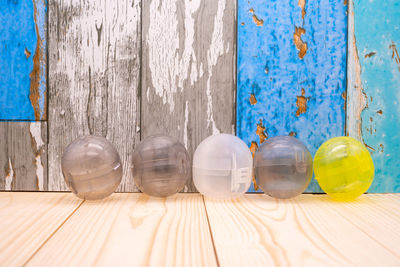 Close-up of glasses on table against blue wall