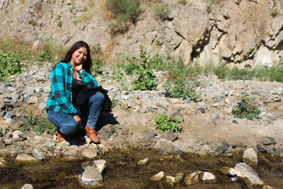 Portrait of woman sitting on rock