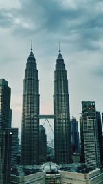 Modern buildings in city against cloudy sky