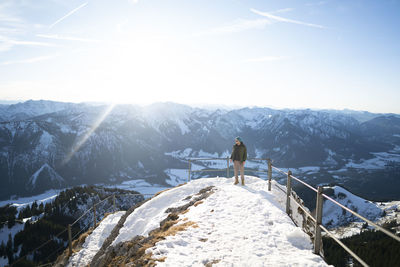 Man looking at snowcapped mountain against sky