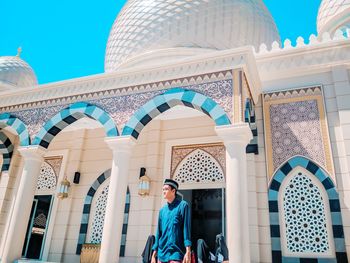 Full length of man standing against building