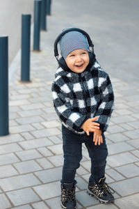 Portrait of boy standing on footpath