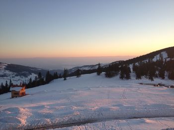 Scenic view of snow covered landscape against sky during sunset