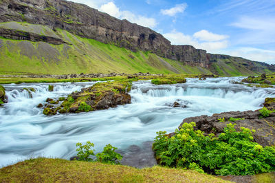 Scenic view of waterfall against sky