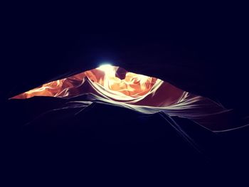 Low angle view of lit candle against black background