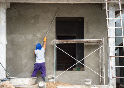 Rear view of man working on building