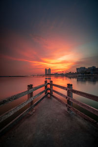 Pier over sea against sky during sunset