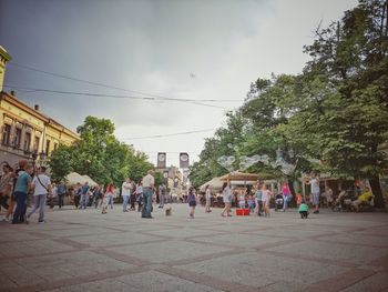 People walking on street against buildings in city