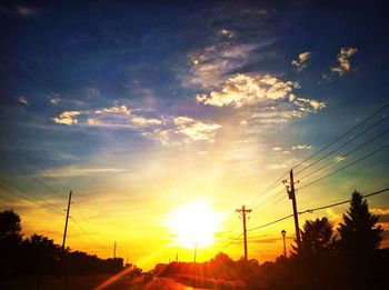 Silhouette of electricity pylon at sunset