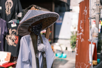 Rear view of monk doll wearing hat