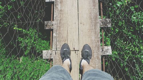 Low section of man standing on wooden floor