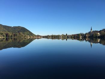 Calm lake against clear blue sky