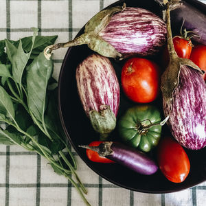 Directly above shot of tomatoes with eggplants and chili peppers in bowl