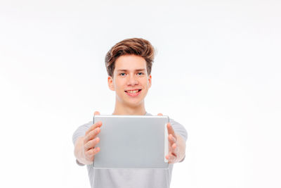 Portrait of smiling girl standing against white background