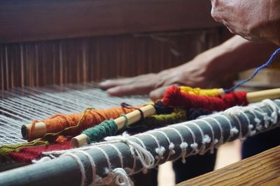 Cropped hands with colorful threads on table