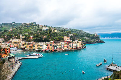 High angle view of townscape by sea against sky