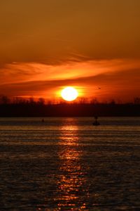 Scenic view of sea against orange sky