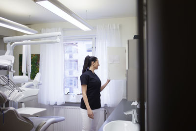 Female dentist standing in surgery