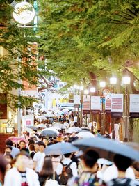 People walking on illuminated street in city