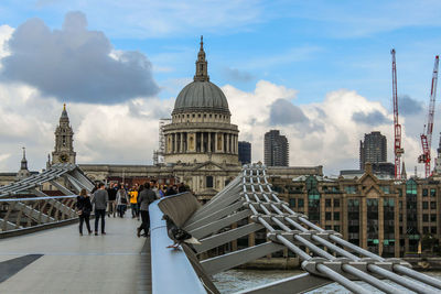 View of buildings in city against cloudy sky