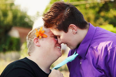 Smiling lesbian couple standing on field at park