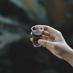 Close-up of hand holding shot glass