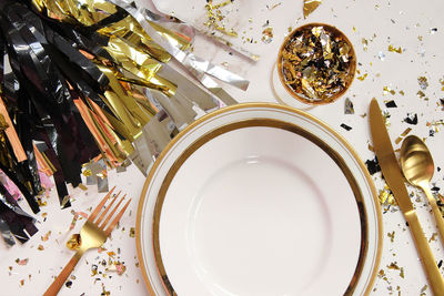 Directly above shot of plates with spoons and decorations on table