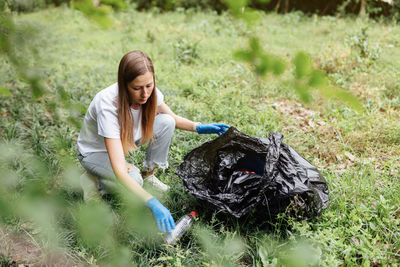 Side view of woman sitting on field