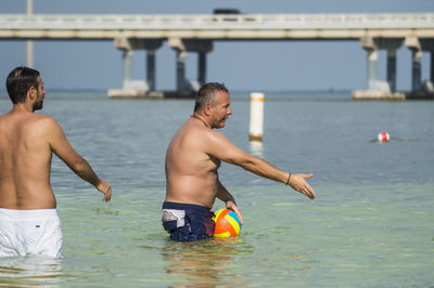 People enjoying in sea against sky