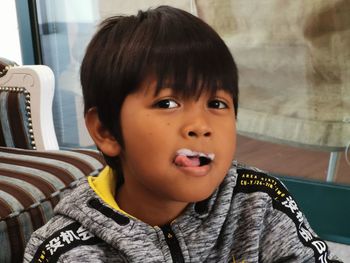 Portrait of cute boy with froth on lips at home