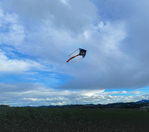 Low angle view of kite flying over land