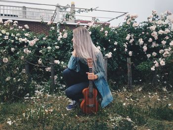 Midsection of woman sitting by plants