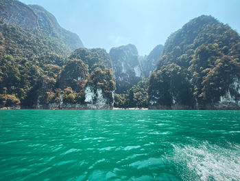 Scenic view of sea and mountains against sky