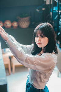 Portrait of a smiling girl standing against curtain