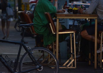 Low section of friends having food and drinks at sidewalk cafe