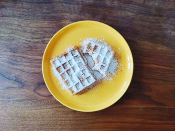 Directly above shot of waffles and power sugar on table