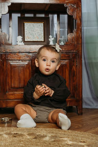 Cute little toddler baby girl in vintage clothes playing at home. gender-neutral baby fashion