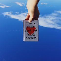 Low angle view of people against blue sky