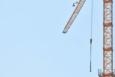 Low angle view of crane against clear sky