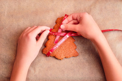 Cropped hands of woman preparing gingerbread cookies on table