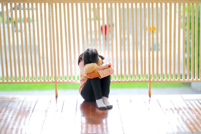 Full length of woman sitting on floor