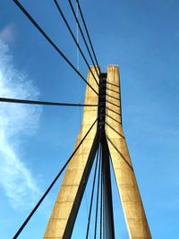 Low angle view of suspension bridge against sky