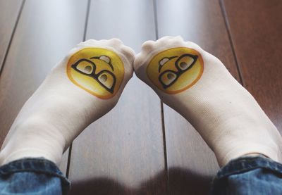 Low section of person wearing socks on hardwood floor