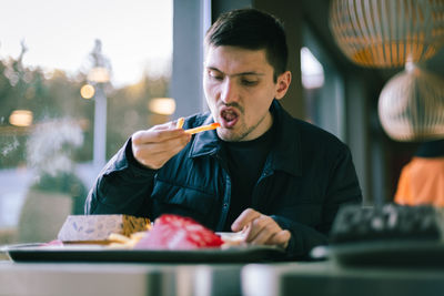 A young man eats fast food at a diner.