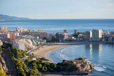 High angle view of cityscape by sea against sky