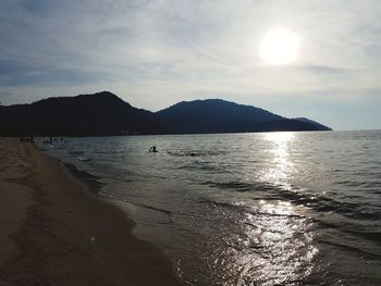 Scenic view of beach against cloudy sky