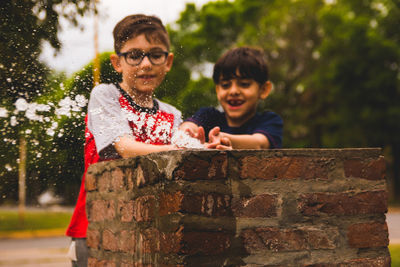 Boys playing with water in drinking fountain outdoors