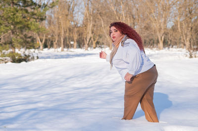 Young woman standing on snow covered field