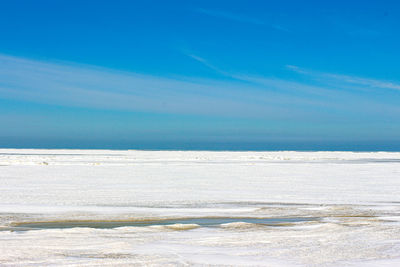 Scenic view of beach against blue sky